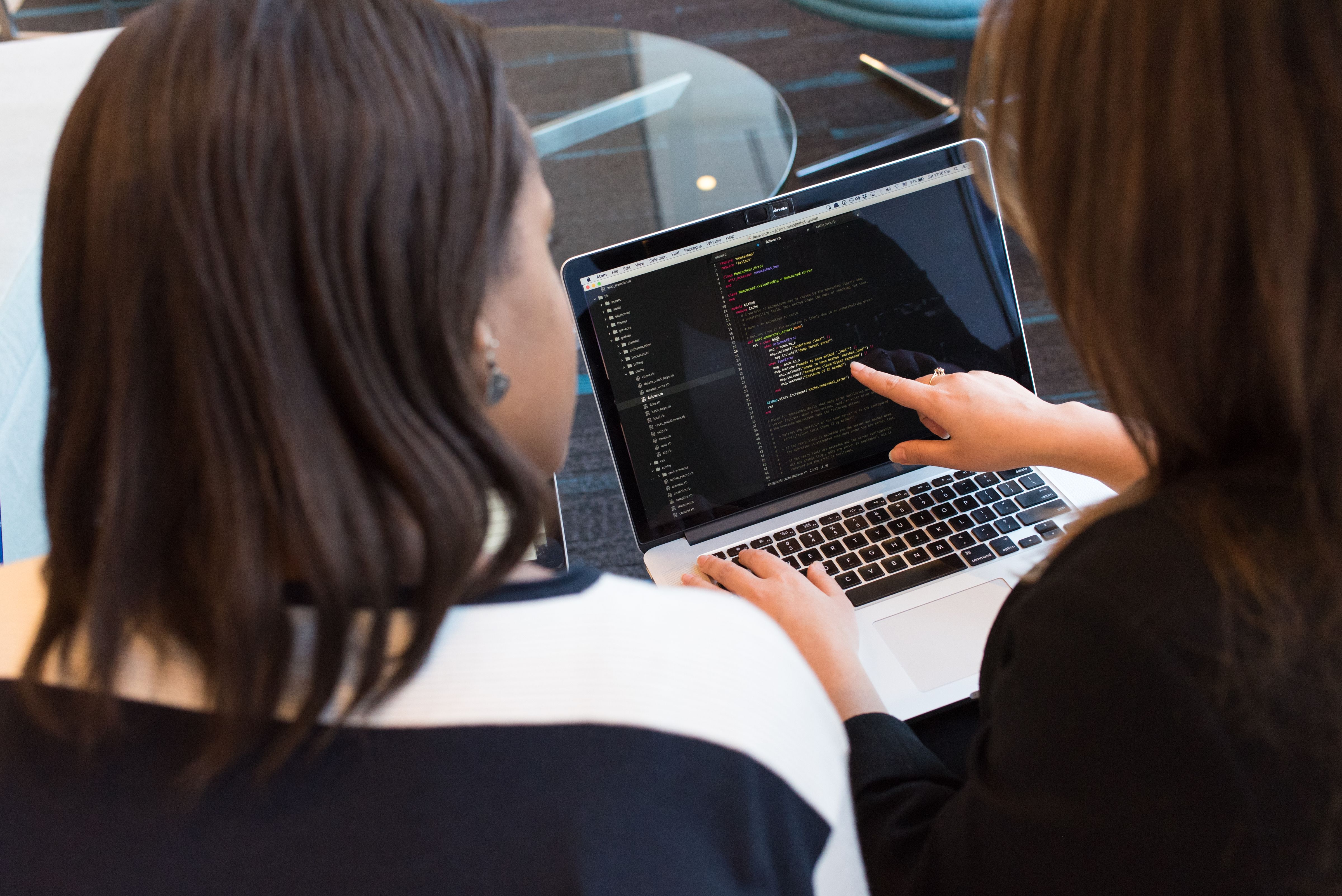 Two QA professionals reviewing a product together on a laptop